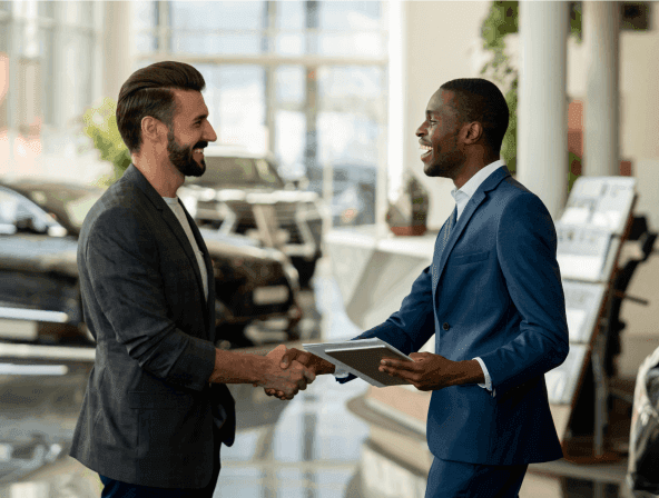 An automotive sales agent shaking hands with a customer