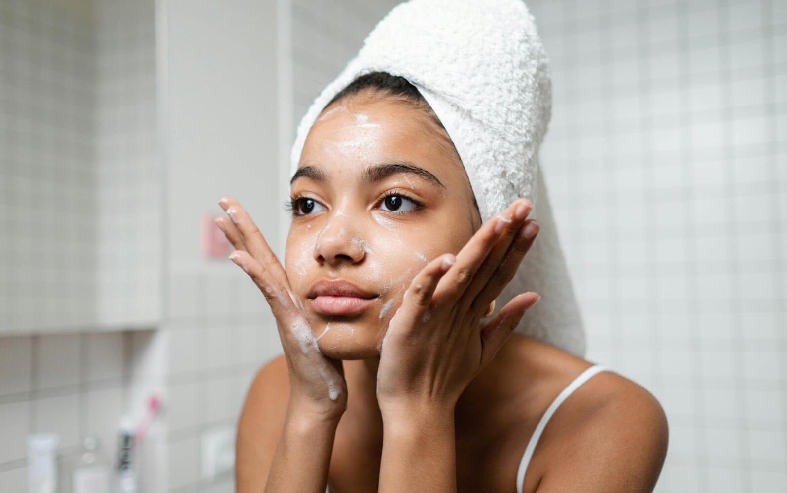 A woman washing her face with a facial cleanser